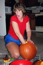 Lynnette carving out the goo from the inside of a pumpkin.