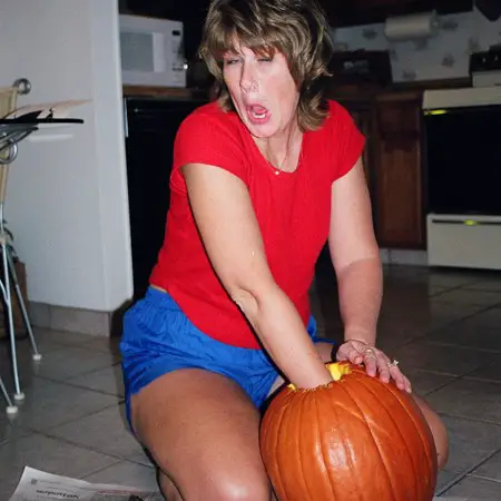 Lynnette scraping out the pumpkin guts.